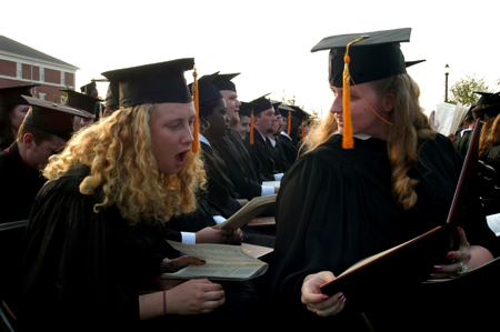 Chemistry graduate Kiera Knappman takes a close look at biology graduate Lindsay Barnes' diploma during spring graduation. - Photo by Brad Moore