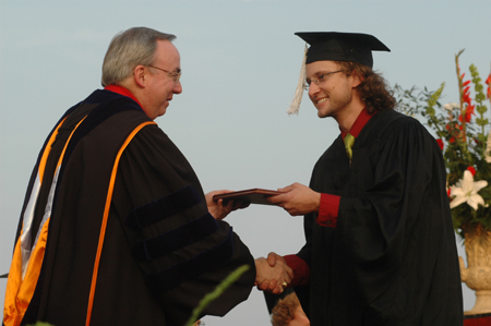 President David S. Dockery presents psychology graduate Tim Weisemann with his degree during spring graduation. - Photo by Jim Veneman