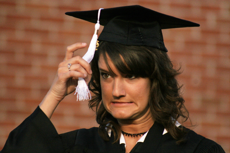 Spanish and TESL graduate Charli Cox almost forgets to move her tassle after receiving her degree at spring graduation. - Photo by Kyle Kurlick