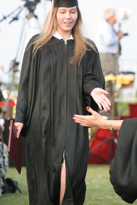 A graduate receives a high-five after walking the line at spring graduation. - Photo by Kyle Kurlick
