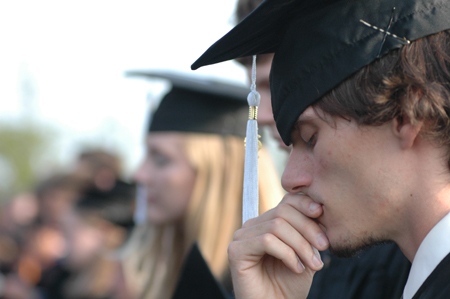 Digital media studies graduate Tyler Malone pauses for reflection during invocation of spring graduation. - Photo by Kristen Nicole Sayres
