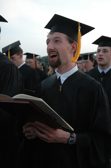 Biology graduate Michael Kieffer joins his fellow graduates in singing the alma mater as alum for the first time at the end of spring graduation. - Photo by Kristen Nicole Sayres