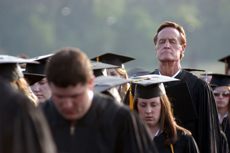 Seventy-two year old graduate Bob Morris towers above the other graduates during the invocation. - Photo by Morris Abernathy