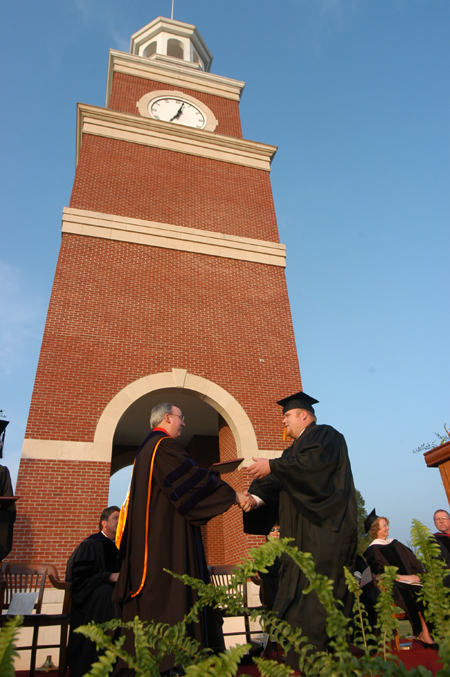 President Dockery presents Matt Oshell with a degree in political science at the spring graduation ceremony. - Photo by Morris Abernathy