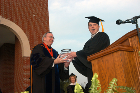 Senior Class President Brandon Nelms presents President Dockery with a fish to represent the senior class gift of a wall-sized aquarium for White Hall. - Photo by Morris Abernathy