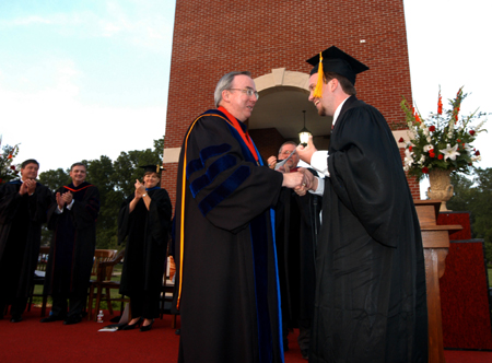 Brian Taylor accepts the Tigrett Medal from President Dockery during spring graduation. Taylor has received a full fellowship and a $23,000 per year stipend for the next five years to do cancer research at M.D. Anderson hospital in Houston, Texas, the premier cancer research center in the country. His work will result in a doctorate from the University of Texas system in medical physics.  - Photo by Morris Abernathy