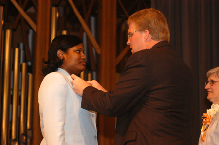 Dean Tim Smith pins Tina Baker during the nursing dedication service - also known as the nurisng pining ceremony. - Photo by Morris Abernathy