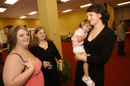 Graduates Becky Johnson and Jodie Curtis (both in black) fellowship with family at the Graduates' Reception. - Photo by Morris Abernathy