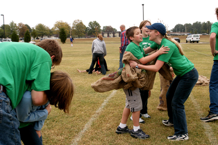 Senior Kelly Krebs congratulates her siblings along with brother Josh after the potato sack race during Family Weekend 2004. - Photo by Kristen Nicole Sayres