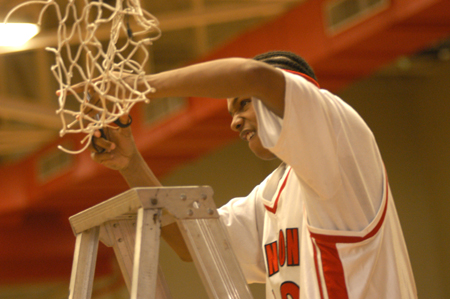 Jonathan Givens (10), a freshman at Union, cuts down his portion of the net after Union's TranSouth Tournament Championship win. - Photo by Jonathan Blair
