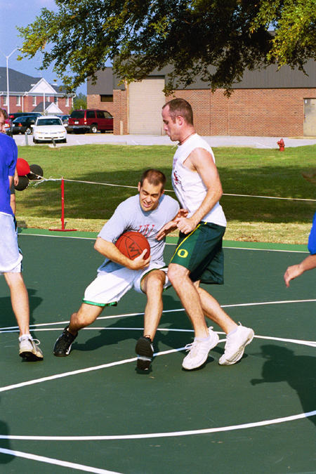Director of Student Discipleship Jay Ridenour drives hard to the hoop against student Senior Youth Ministry major Michael Talley during the Faculty/Staff vs. Student game at the dedication of the Class of 2002 Basketball Court.  - Photo by Justin Veneman