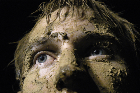 Junior Tony Winkler shows off his accumulation of mud during the Young Alums' Midnight Mudness. - Photo by Kathleen Murray
