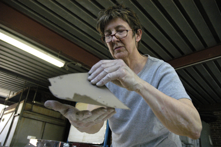 Artist Berry Matthews, who lead a sculpture workshop for art students, curls the end of a thinly sliced piece of clay. - Photo by Kathleen Murray
