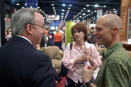 Union President David S. Dockery talks to Jonathan Newman ('90) and his wife Jeni at the Union booth during the Southern Baptist Convention. - Photo by Brad Moore