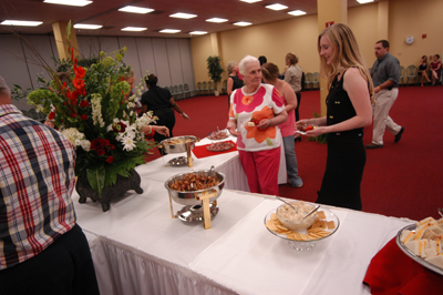 Theology graduate Kelly Krebs enjoys food and fellowship at the Graduates' Reception. - Photo by Morris Abernathy