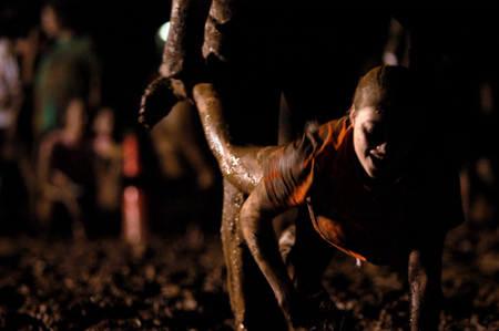 Juniors play a muddy wheelbarrow game during the Young Alums' annual Midnight Mudness event. - Photo by Kristen Nicole Sayres