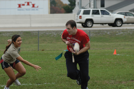 Jeremy Cathey makes a move with the turkey while Darilynn Keith reaches for his flag during the Young Alums' Turkey Bowl. - Photo by Kristen Hiller