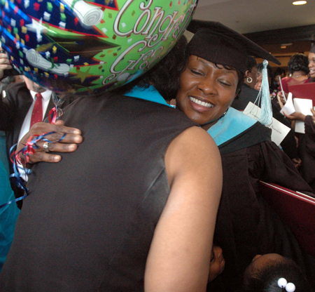 An education graduate receives a big hug after summer graduation. - Photo by Jim Veneman