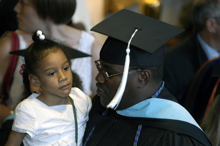 An education graduate celebrates with his daughter after summer graduation. - Photo by Kathleen Murray