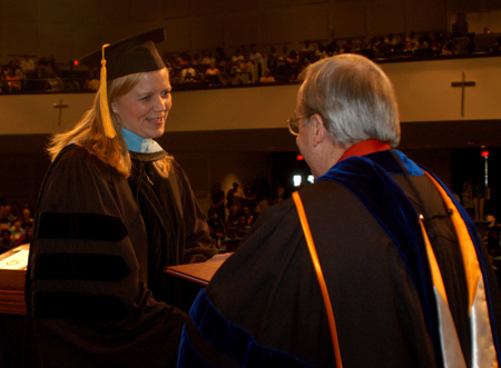 An education graduate accepts her diploma from President Dockery during summer graduation. - Photo by Morris Abernathy