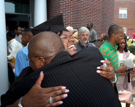 A graduate receives a big hug after summer graduation. - Photo by Morris Abernathy