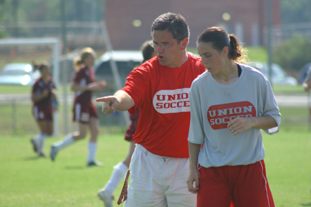 Freshman Nikki Burau looks on as Coach Boylan paints a picture of what she needs to do during the scrimmage. - Photo by Kyle Kurlick