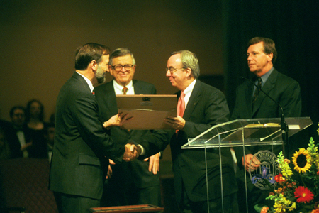 President David S. Dockery congratulates Dr. Hal Poe on receiving the position of Chuck Colson Chair of Faith and Culture. - Photo by Jim Veneman