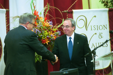 President David S. Dockery welcomes Chuck Colson to the stage at the Red Carpet Banquet. - Photo by Jim Veneman