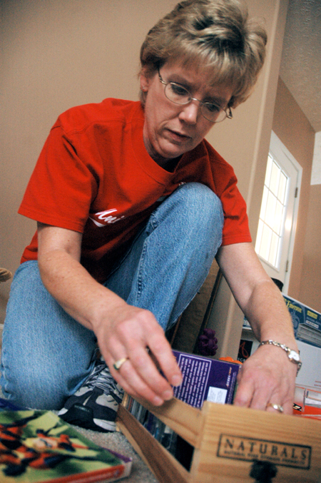 Cheryl Mercker of Health Services helps clean and organize the house of a mother and her three children during the Day of Remembrance. - Photo by Brad Moore