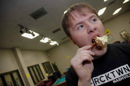 Senior Brad Moore enjoys a caramel apple during SAC's Fallapalooza.  - Photo by Kristen Nicole Sayres