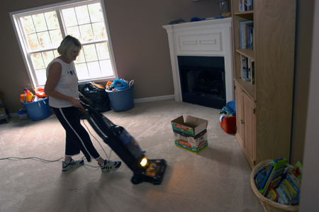 Carol Courtner, enrollment services secretary, helps clean a resident's room at Alexandria Place, an assisted living facility, as part of Day of Remembrance.  - Photo by Morris Abernathy
