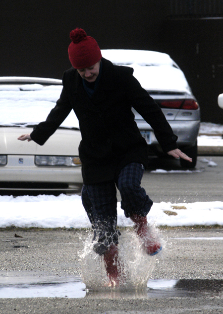 Lindsey Abell creates some puddle fun as the ice begins to melt. - Photo by Stephanny Rodriguez