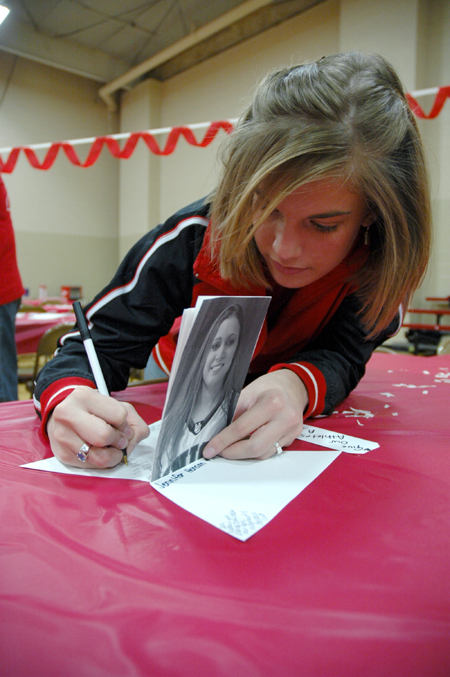 Heather Childers signs a card encouraging Jennifer Henson during the World's Largest Tailgate Party. - Photo by Brad Moore