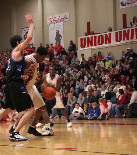 Junior forward Deywane Lee (24) works to score on a Mountain State (W. Va.) defender during Union's win at Homecoming.  Senior guard Corey Burkett (45) watch's from beyond the arc. - Photo by Kyle Kurlick