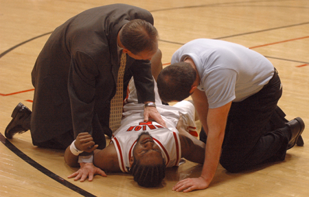 Union men's basketball trainer and athletic training instructor Cliff Pawley (left) along with student trainer Adam Raines (right) take care of an injured Marcus Cooper during a Union basketball game. - Photo by Brad Moore