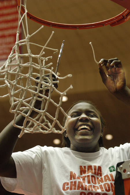 Freshman Josephine Owino, who was also named to the all tournament second team, helps cut down the nets after Union's 79-62 victory over Lubbock Christian. The Lady Bulldogs secured their second consecutive NAIA national championship with the win. - Photo by Jim Veneman
