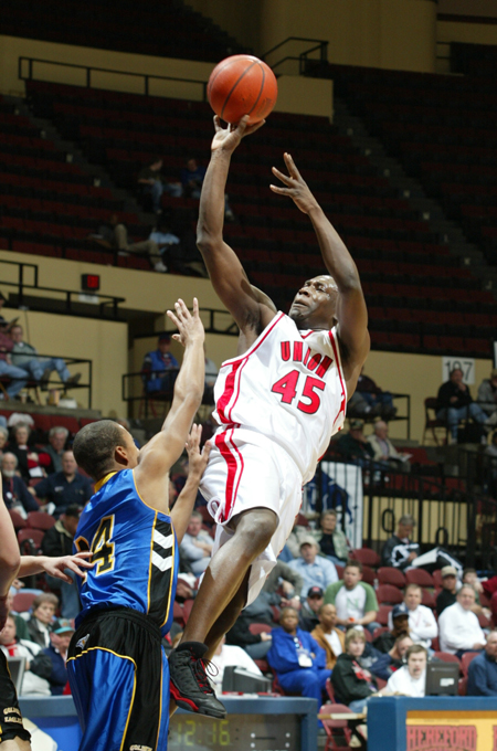 Corey Burkett (45) takes a shot over a John Brown defender in the first round of the NAIA National Tournament. - Photo by Uncredited