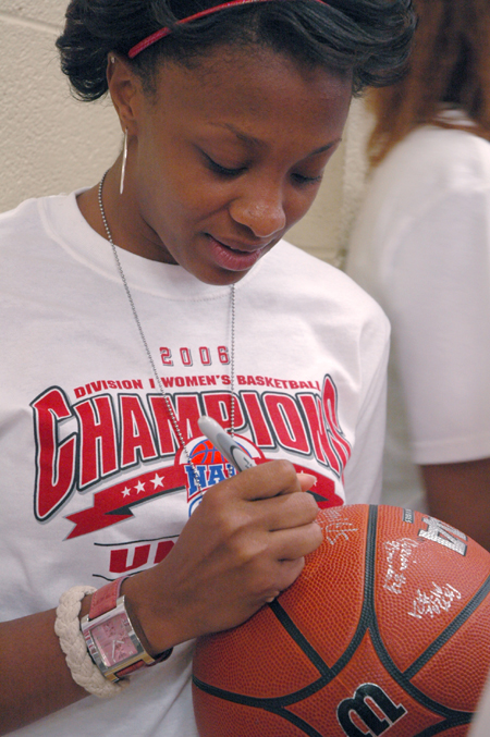 Senior guard Ena Daniels autographs a basketball for a fan during the April 7 celebration honoring Union's 2006 NAIA National Title. - Photo by Kristen Nicole Sayres