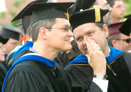 Department chairmen Gene Fant (right) of English and Troy Riggs (left) of mathematics share some conversation during the processional at spring graduation ceremonies on the Great Lawn. - Photo by Matthew Diggs