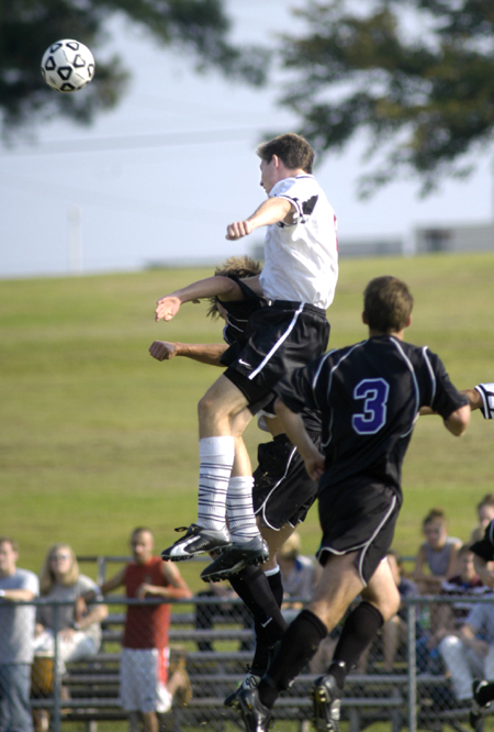 Union midfielder Duncan Nicol (white) leaps above the competition to head the ball to a teammate. - Photo by Kathleen Murray
