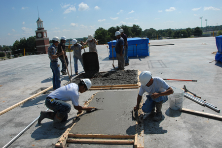 Workers lay concrete on the roof of White Hall. - Photo by Morris Abernathy