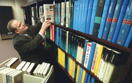 Brian Denker, a Union graduate and part-time employee, organizes and assembles books and reference materials in the R.C. Ryan Center for Biblical Studies, located in Jennings Hall, which will open in April 2003. - Photo by Jim Veneman