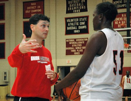 Mark Campbell, Head Coach of the Lady Bulldogs, gives direction to freshman center Josephine Owino. - Photo by Brad Moore