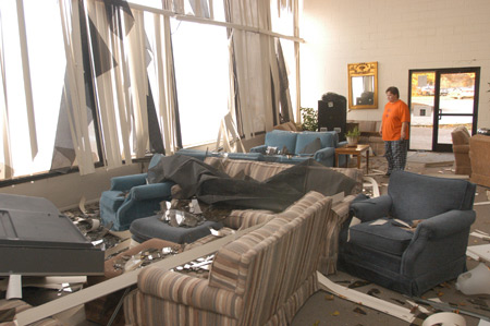 Pam Schock, Residence Director for Hurt Commons, surveys the damage done to the large windows in the Hurt Commons as a result of the tornado that hit campus Saturday night.  - Photo by Jim Veneman