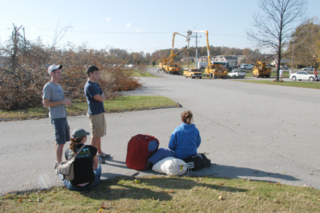Temporarily-displaced students watch power line repairs as they wait for shuttle buses to donated rooms at the nearby Jameson Inn. - Photo by Jim Veneman