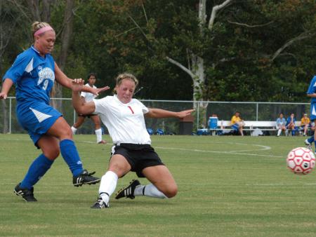 Sophomore Caitlin Zimmerman slides in front of a Brescia player to intercept the ball. - Photo by Steven Aldridge