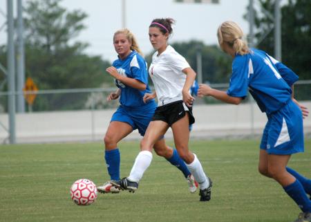 Roxanna Skelton, freshman defender (white jersey), dribbles the ball away from Brescia (Ky.) players. - Photo by Steven Aldridge