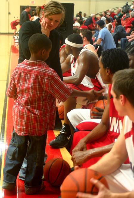 Freshman Amy Brown brings a young friend of hers to meet some of the players on the men's basketball team during Bulldog Madness. - Photo by Stephanie Schroeder