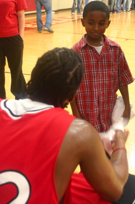 A young friend of Freshman Amy Brown meets Sophomore Mack Bealim from the men's basketball team during Bulldog Madness. - Photo by Stephanie Schroeder