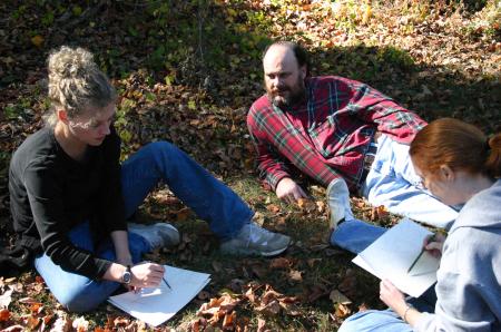 Professors Lee Benson and Lori Nolen talk with Angela McDaniel, art department secretary, as they participate in a drawing project during the art retreat. - Photo by Stephanie Schroeder